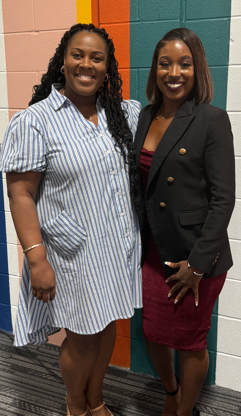 Ashley with a client in front of a colorful mural