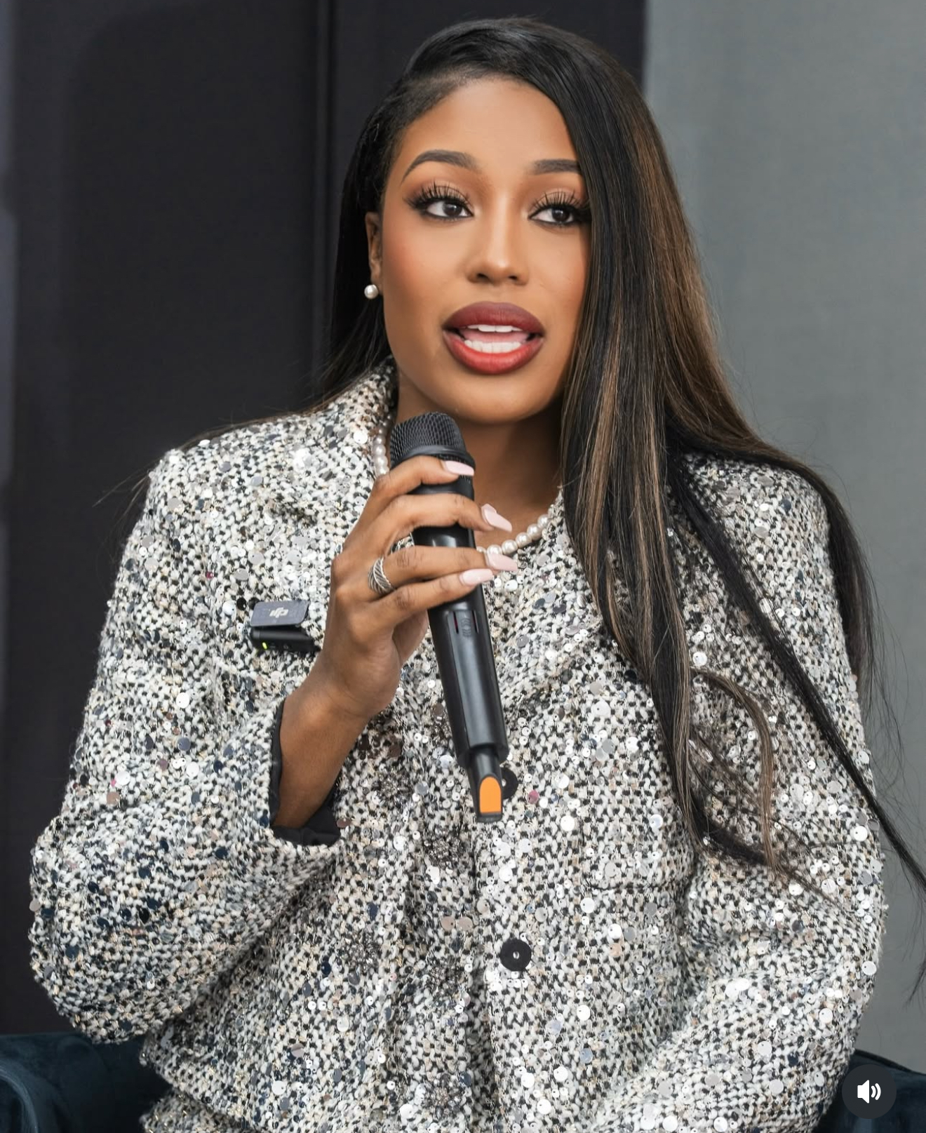 Ashley holding a microphone while speaking at an event